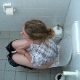 A daring cameraman video records an unsuspecting blonde girl using the adjacent toilet stall in a public restroom as she takes a shit and piss. 2 scenes. Loud plops in the first scene with good wiping. About 5.5 minutes.